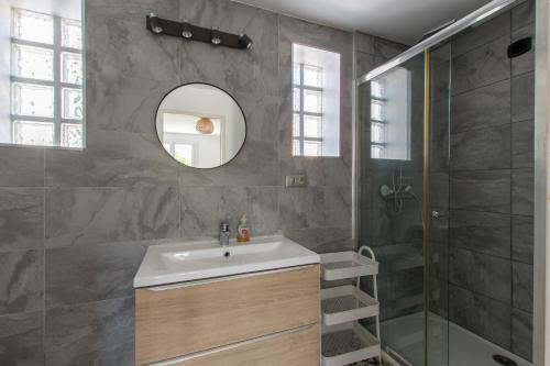 ein Bad mit einem Waschbecken, einer Dusche und einem Spiegel in der Unterkunft Très belle Villa classée 4* à La Grande Motte in La Grande-Motte