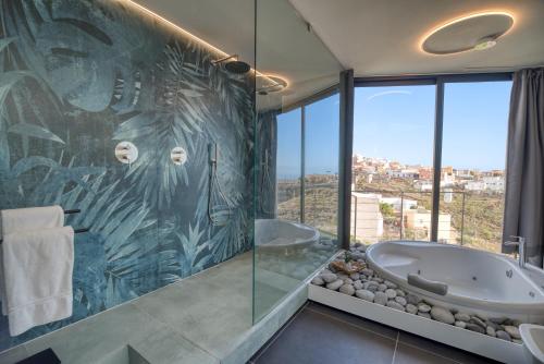 a bathroom with a tub and a large window at House Gallery 10 in Tijoco de Abajo