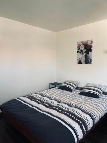ein Bett in einem Schlafzimmer mit einem Bild an der Wand in der Unterkunft Studio, Maison, rez de chaussée, Perpignan in Perpignan