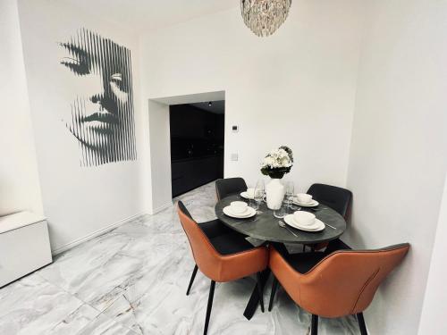 a dining room with a black table and orange chairs at Nirvana in Manchester