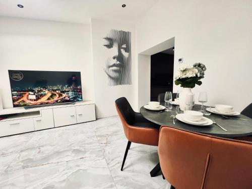 a dining room with a table and a tv at Nirvana in Manchester