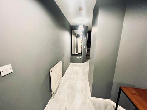 a room with a hallway with gray walls and a white tile floor at Nirvana in Manchester