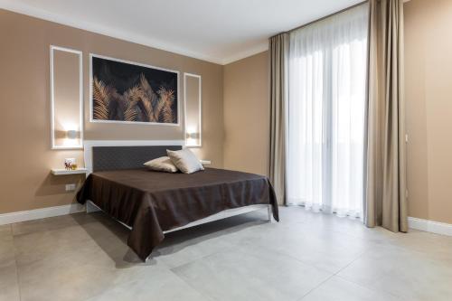 a bedroom with a bed and a large window at Le Palme in Terrasini