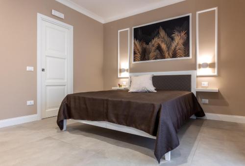 a bedroom with a bed and a painting on the wall at Le Palme in Terrasini