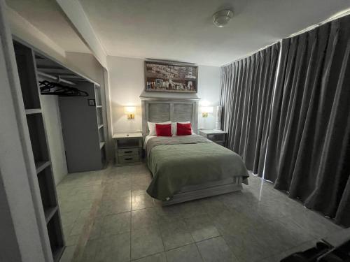 a bedroom with a bed with two red pillows at 5 VENATOR House Boutique in León