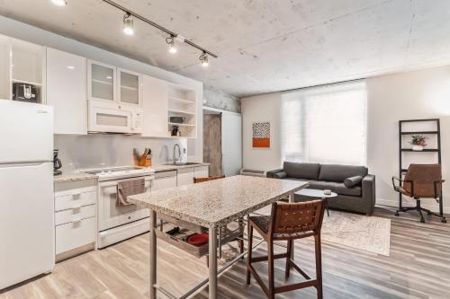 a kitchen and living room with a table and a couch at Sleek downtown Cleveland apartment in Cleveland