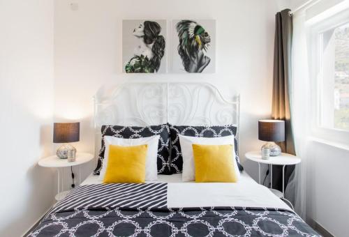 a bedroom with a black and white bed with yellow pillows at House Matenda house in Solin