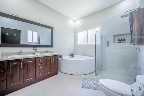 a bathroom with a tub and a toilet and a sink at Jacarandas 4 in Tamarindo
