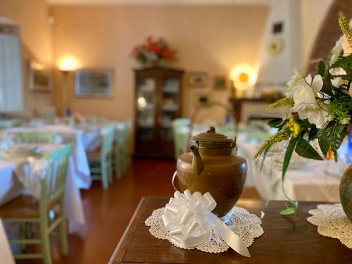 a room with tables and a vase with flowers on a table at Agriturismo Campo Al Sole in Castell’Anselmo