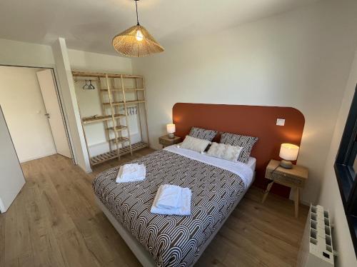 a bedroom with a bed with two towels on it at Pointe du Raz in Vannes