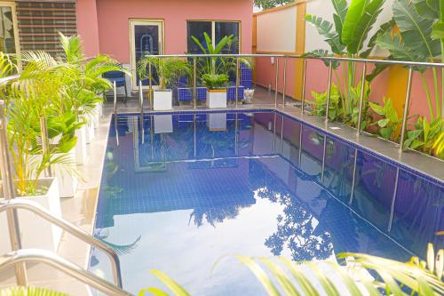 ein Pool mit Pflanzen in einem Gebäude in der Unterkunft Sugarland Hotel and Suite in Ikeja
