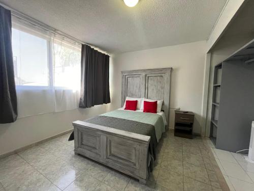 a bedroom with a bed with two red pillows at 7 VENATOR House Boutique in León