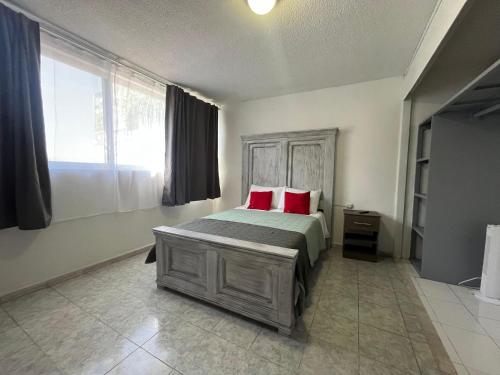 ein Schlafzimmer mit einem Bett mit zwei roten Kissen in der Unterkunft 7 VENATOR House Boutique in León