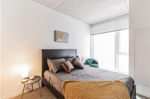a bedroom with a bed and a chair and a window at DT Delight Downtown Living Two-Bedroom Endless Access in Cleveland