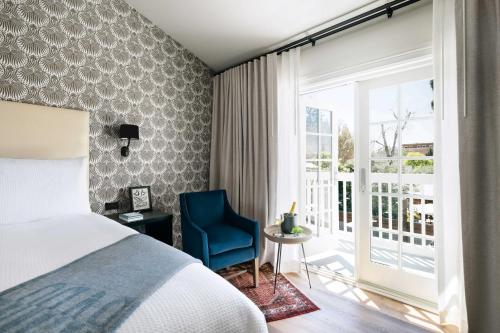 um quarto com uma cama e uma cadeira azul e uma janela em El Dorado Hotel em Sonoma