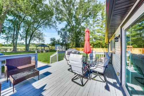 a deck with a table and chairs and a umbrella at Dock, Kayaks, Game Room Lakefront Antioch Home! in Antioch