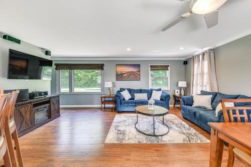 a living room with blue couches and a table at Dock, Kayaks, Game Room Lakefront Antioch Home! in Antioch