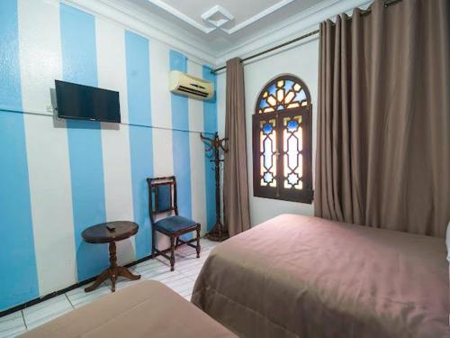 sypialnia z łóżkiem, krzesłem i oknem w obiekcie Hotel Sevilla w mieście Szafszawan