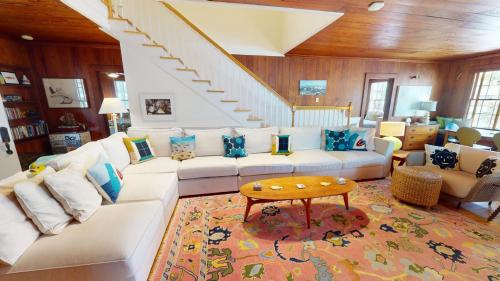 a living room with a white couch and a staircase at 3 10th Place by Tybee Vacation Rentals in Tybee Island