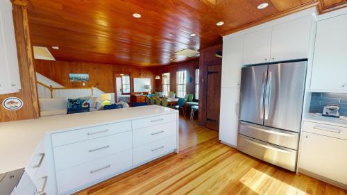 a kitchen with white cabinets and a stainless steel refrigerator at 3 10th Place by Tybee Vacation Rentals in Tybee Island