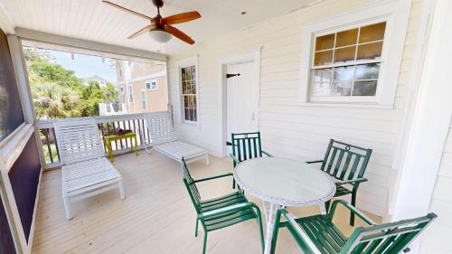 a porch with a table and chairs and a ceiling fan at 3 10th Place by Tybee Vacation Rentals in Tybee Island
