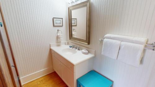a white bathroom with a sink and a mirror at 3 10th Place by Tybee Vacation Rentals in Tybee Island