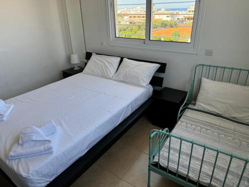 a small bedroom with a bed and a window at Cosy apartment at Mythical Sands resort in Paralimni