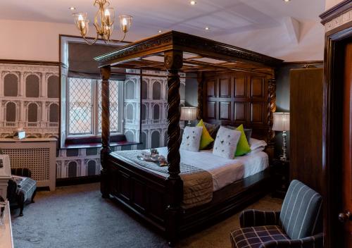 a bedroom with a canopy bed and a window at Broadoaks Boutique Country House in Windermere