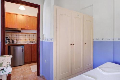 a kitchen with a white cabinet in a room at Areti Orfeas Studios in Vasilikos