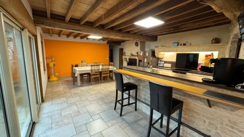 une cuisine avec un comptoir, des chaises et une table dans l'établissement Corps de ferme bourguignon, à Nitry