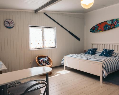 a bedroom with a bed and a window and a table at Costanova Surfhouse in Ílhavo