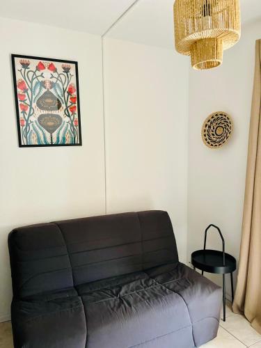 un salon avec un canapé et un tableau au mur dans l'établissement BARCARES PLAGE - Appt refait à neuf, au Barcarès