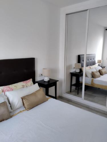 a bedroom with two beds and a large mirror at Pueblo Evita Hill in Benalmádena