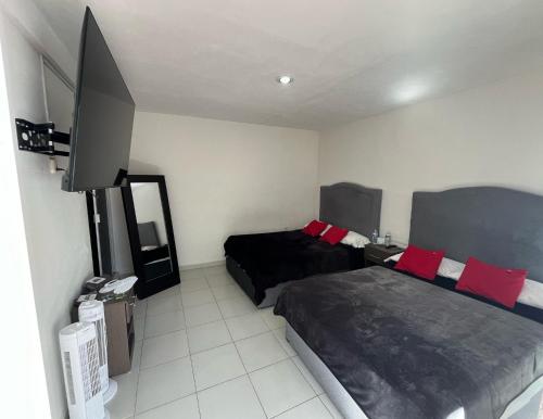 a bedroom with two beds and a flat screen tv at 11 VENATOR House Boutique in León