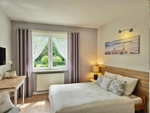 a bedroom with a bed and a window at Apartament Garden- parking, ogródek, cicha okolica in Pruszcz Gdański