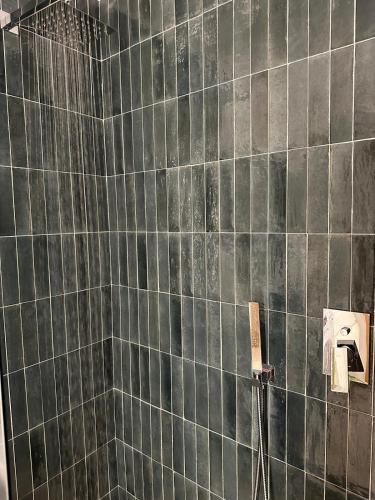 a black tiled bathroom with a shower with a hose at Only One Piccolo Pevero in Arzachena