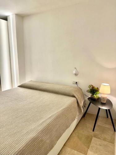 a bedroom with a bed and a table with a lamp at Only One Piccolo Pevero in Arzachena