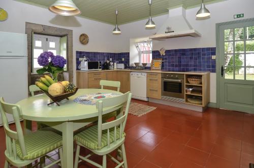 a kitchen with a table with a bowl of fruit on it at Casa da Igreja Velha in Furnas