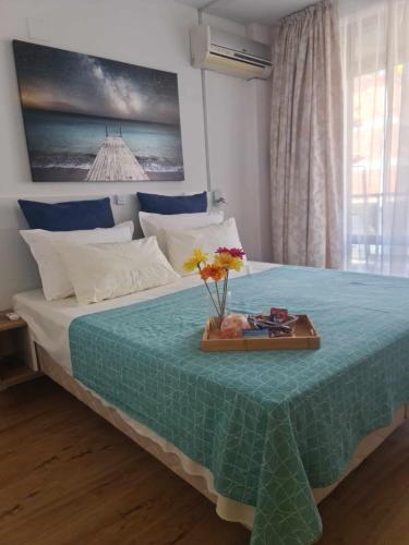 a bedroom with a bed with a tray with flowers on it at Aglaya 2 - Pomorie Bay in Pomorie
