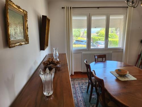 une table à manger avec un vase au-dessus dans l'établissement Villa Martigues, à Martigues