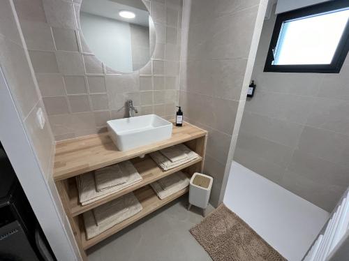 ein kleines Badezimmer mit Waschbecken und Spiegel in der Unterkunft Belle-Île in Vannes