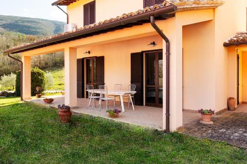 a patio of a house with a table and chairs at Relais Parco Del Subasio in Piano Delle Pieve