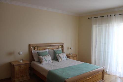 Un dormitorio con una cama con almohadas y una ventana. en CountrySide Villa, en São Brás de Alportel