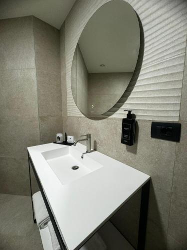 a bathroom with a white sink and a mirror at Acca Sporting Milano - AA Hotels in Opera