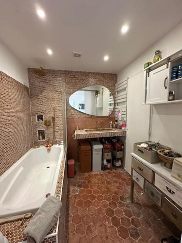 une salle de bain avec une baignoire, un lavabo et un miroir dans l'établissement la touR d'azuR, à La Cadière-dʼAzur