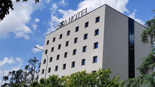 a white building with a sign on top of it at Acca Sporting Milano - AA Hotels in Opera