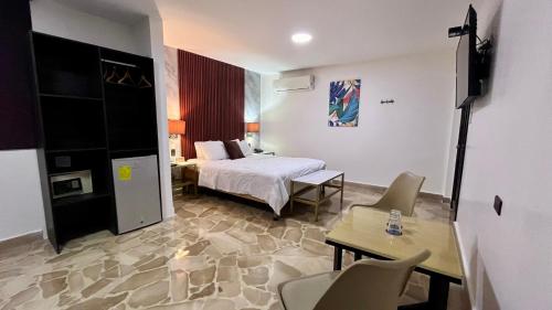 um quarto de hotel com uma cama, uma mesa e cadeiras em Hotel Varadero Internacional em Guayaquil