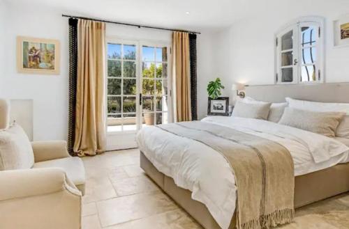 une chambre avec un grand lit et une fenêtre dans l'établissement La Pastourelle, au Cannet