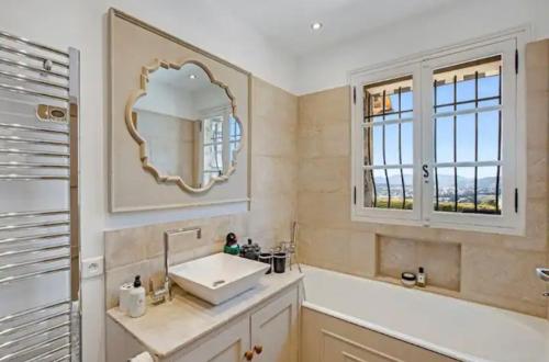 une salle de bain avec un lavabo et un miroir dans l'établissement La Pastourelle, au Cannet