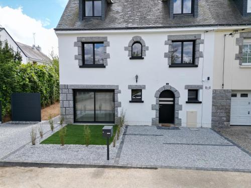 an exterior view of a white house with a yard at Pointe du Raz in Vannes